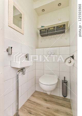 Stylish and functional bathroom featuring a clean aesthetic with white tiles, a sleek sink, and modern fixtures, exemplifying minimalist design principles. Stylish and functional bathroom featuring a clean aesthetic with white tiles, a sleek sink, and modern fixtures, exemplifying minimalist design principles. 125503868