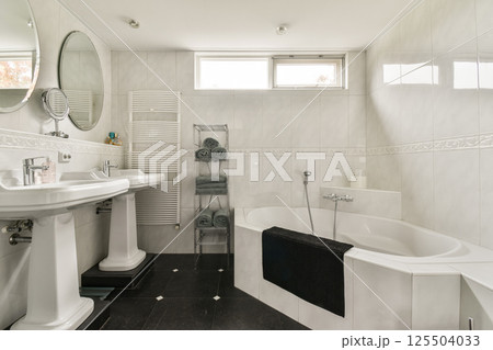 A stylish and spacious bathroom featuring modern fixtures, a luxurious bathtub, and elegant design elements that create a serene atmosphere. A stylish and spacious bathroom featuring modern fixtures, a luxurious bathtub, and elegant design elements that create a serene atmosphere. 125504033