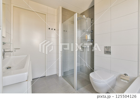 Contemporary bathroom featuring sleek fixtures, a glass shower, and minimalist decor. A perfect blend of style and functionality. Contemporary bathroom featuring sleek fixtures, a glass shower, and minimalist decor. A perfect blend of style and functionality. 125504126