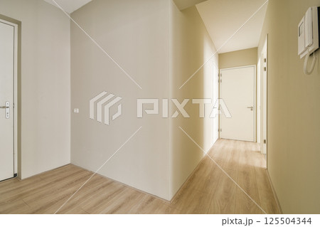 A clean, minimalist hallway featuring neutral tones and simple lines, emphasizing space and light. Ideal for modern interior aesthetics. A clean, minimalist hallway featuring neutral tones and simple lines, emphasizing space and light. Ideal for modern interior aesthetics. 125504344