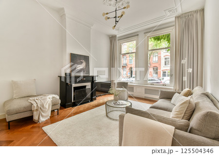 An elegantly designed living room featuring contemporary furniture, large windows, and warm lighting, creating a cozy atmosphere for relaxation and gatherings. An elegantly designed living room featuring contemporary furniture, large windows, and warm lighting, creating a cozy atmosphere for relaxation and gatherings. 125504346