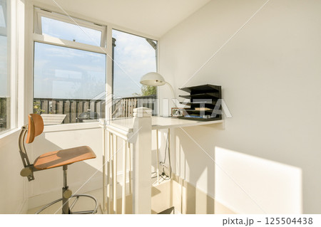 Bright and airy home office featuring a sleek desk, stylish chair, and ample natural light, ideal for productivity and creativity. 125504438