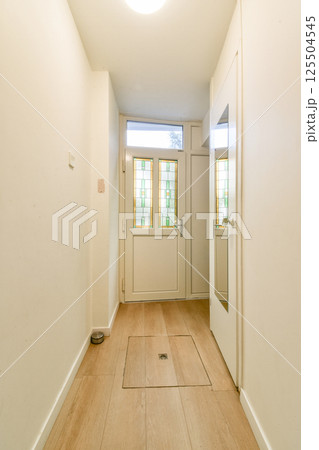 Spacious hallway featuring a modern design, illuminated by natural light, and characterized by clean lines and minimalistic decor elements. 125504545