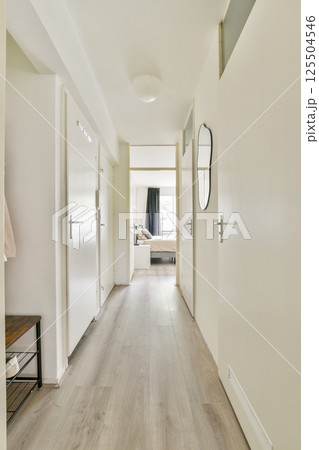 A spacious and well-lit hallway featuring modern doors, wooden flooring, and minimal decor elements, creating an inviting atmosphere for residents and guests. 125504546