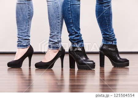 Female legs in denim pants heeled shoes Female legs in denim pants heeled shoes 125504554