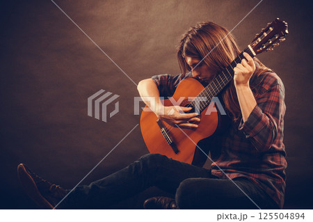 Artist with his wooden guitar. 125504894