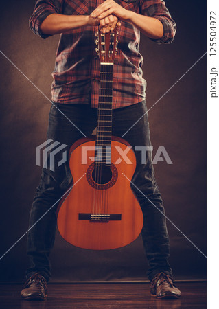 Artist is standing with wooden guitar. Artist is standing with wooden guitar. 125504972