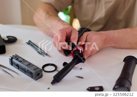 Hands of skilled workers diligently engaged in the intricate repair of mechanical devices Hands of skilled workers diligently engaged in the intricate repair of mechanical devices 125506212