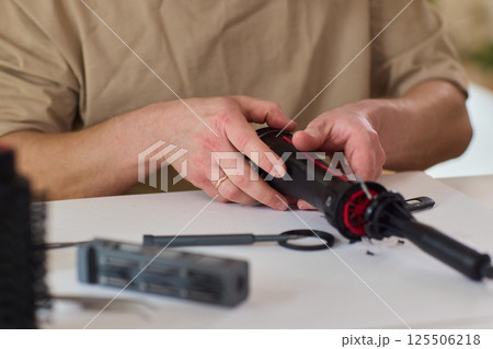 Hands of skilled workers diligently engaged in the intricate repair of mechanical devices Hands of skilled workers diligently engaged in the intricate repair of mechanical devices 125506218
