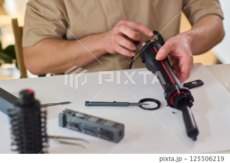 Hands of skilled workers diligently engaged in the intricate repair of mechanical devices 125506219
