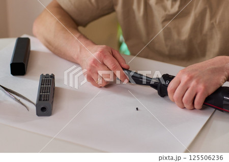 Hands of skilled workers diligently engaged in the intricate repair of mechanical devices Hands of skilled workers diligently engaged in the intricate repair of mechanical devices 125506236
