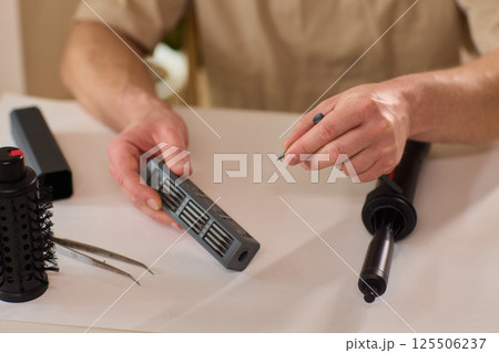 Hands of skilled workers diligently engaged in the intricate repair of mechanical devices Hands of skilled workers diligently engaged in the intricate repair of mechanical devices 125506237