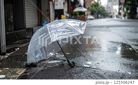 《AI画像》ゲリラ豪雨の中、壊れて捨てられたビニール傘 125506247