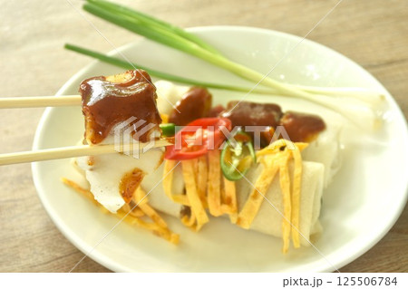 fresh Chinese spring roll made from flour wrapped tofu and pork with bean sprout dressing sweet red gravy sauce on plate    125506784