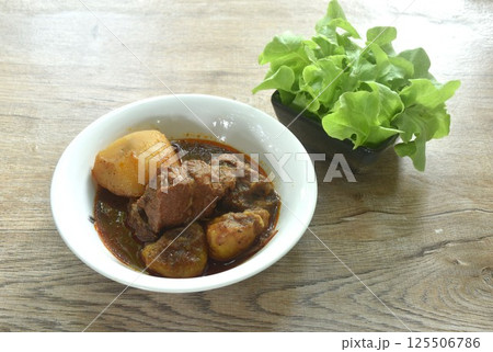 beef curry or Mussamun Indian food with slice potato on bowl eat with fresh green oak beef curry or Mussamun Indian food with slice potato on bowl eat with fresh green oak 125506786
