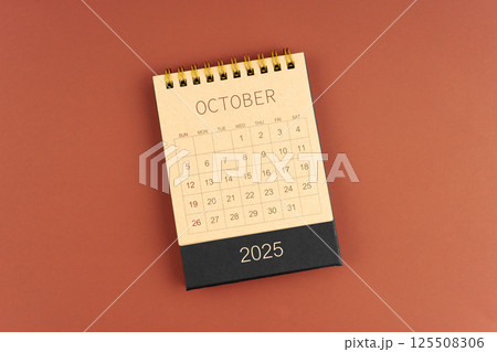 October 2025 calendar from brown craft paper on red background. 125508306