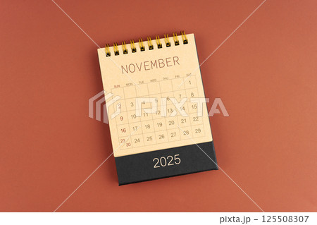 November 2025 calendar from brown craft paper on red background. 125508307