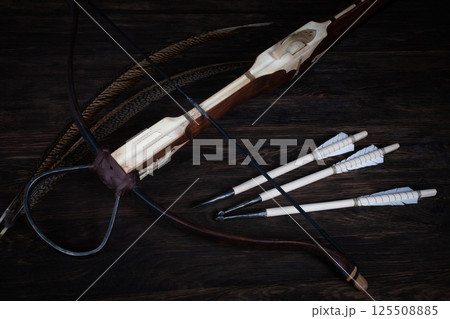 vintage medieval crossbow with bolts on wooden table 125508885