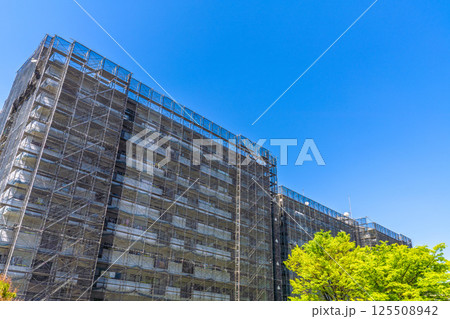 日本の横浜都市景観　マンションの補修や点検等、足場や防護ネットなど。ネットの外に衛星アンテナが… 125508942