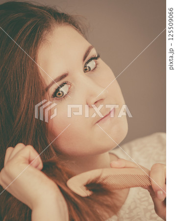 Angry woman trying to brush her hair 125509066