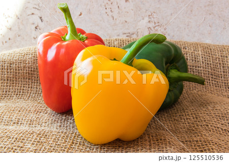 Three sweet paprika on the natural background. Red, yellow, green fresh pepper. Healthy, vegan and diet food. Three sweet paprika on the natural background. Red, yellow, green fresh pepper. Healthy, vegan and diet food. 125510536