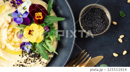 Gourmet Hummus with Edible Flowers, Black Sesame, and Pine Nuts 125511914