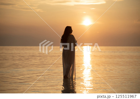 Woman Walking on Beach at Sunset Silhouette Scene 125511967