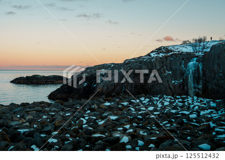 Serene Coastal Sunset with Rocky Shore at Lofoten Island 125512432