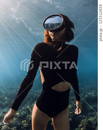 Sexy woman close up undersea. Gorgeous female freediver underwater in blue sea. 125512659