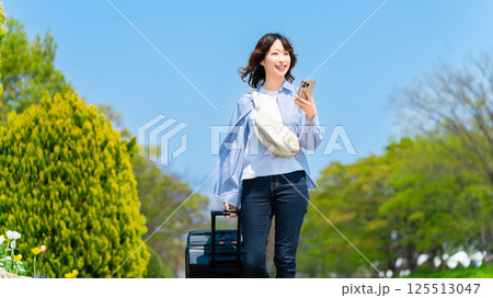 キャリーケースを持って旅行する女性 125513047