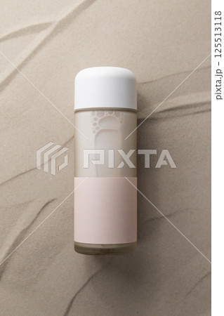 Moisturizing cosmetic milk in glass packaging on sand, empty label, minimalist design Moisturizing cosmetic milk in glass packaging on sand, empty label, minimalist design 125513118