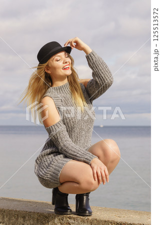 Woman wearing fedora and jumper outdoor 125513572