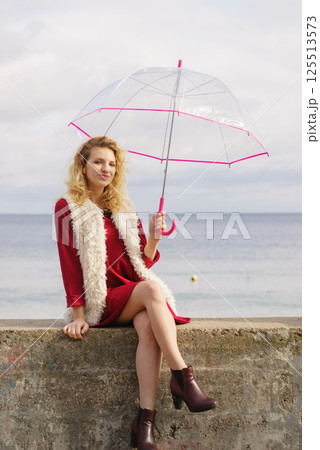 Happy woman holding umbrella Happy woman holding umbrella 125513573
