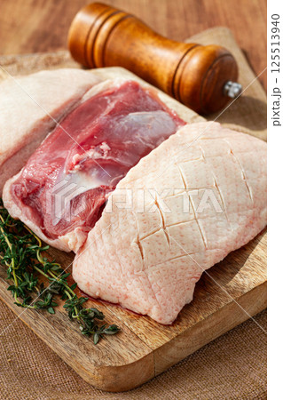 Fresh raw duck breast, on a wooden chopping board, top view, no people, 125513940