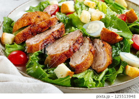 Caesar salad, with duck breast, on a light plate, on a light background, homemade, no people, 125513948