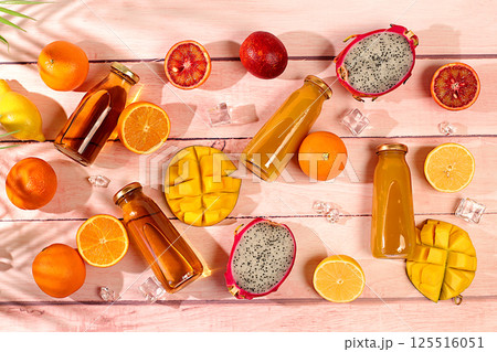 Summer exotic tropical fruits. Dragon fruit, pitahaya, mango, blood orange, lemons, kiwi, oranges and fresh juices, banner for a cafe or store, postcard for advertising an Asian market 125516051