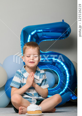 Happy Five Year Old Boy Celebrating Birthday with Cupcake and Candle Happy Five Year Old Boy Celebrating Birthday with Cupcake and Candle 125516219