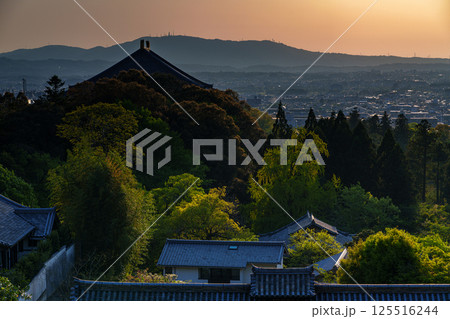 東大寺二月堂の夕焼け空　空と境内を黄金色に染めながら生駒の山並みに沈んで行く夕日⑤ 125516244