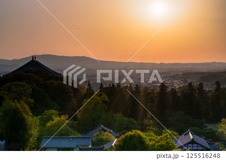 東大寺二月堂の夕焼け空　空と境内を黄金色に染めながら生駒の山並みに沈んで行く夕日⑨ 125516248