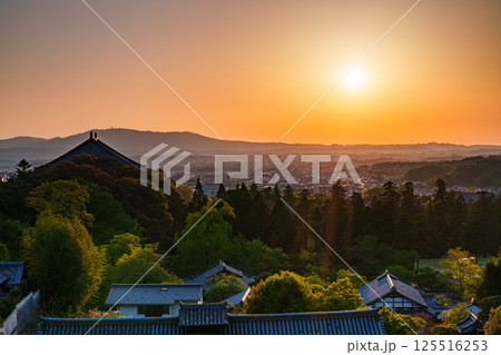東大寺二月堂の夕焼け空　空と境内を黄金色に染めながら生駒の山並みに沈んで行く夕日⑭ 125516253
