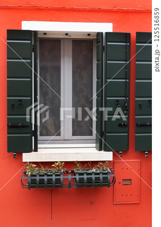Red house wall with green shutters and window box Red house wall with green shutters and window box 125516859