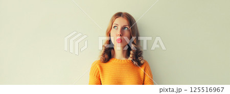 Pensive caucasian young woman thinks looking away Pensive caucasian young woman thinks looking away 125516967