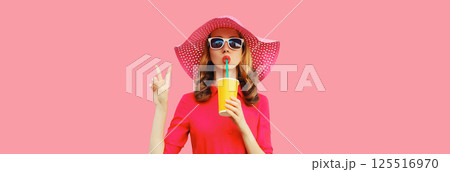 Summer portrait of beautiful young woman drinking fresh juice wearing straw hat, pink dress Summer portrait of beautiful young woman drinking fresh juice wearing straw hat, pink dress 125516970