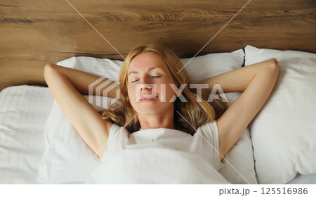 Woman sleeping lying in bed on white soft comfortable pillow in bedroom at home Woman sleeping lying in bed on white soft comfortable pillow in bedroom at home 125516986