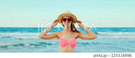 Summer vacation, beautiful happy young woman in bikini swimsuit, tourist hat on the beach on sea 125516996