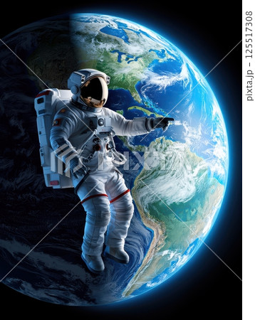 An astronaut floats in space pointing towards Earth illuminated by sunlight. The vivid blues and greens of the planet contrast with the dark backdrop showcasing the beauty of our home. 125517308