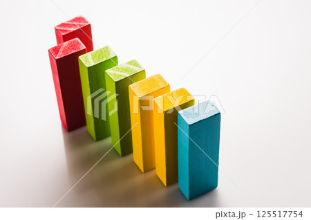 Educational toys in the form of wooden blocks encourage the exploration of shapes and colors. Colorful construction toys are placed on a clean white background to focus attention. 125517754