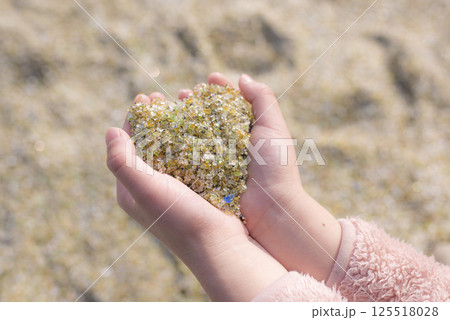 手のひらに集めたハート型のガラス砂 手のひらに集めたハート型のガラス砂 125518028
