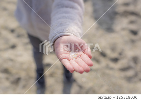 ガラスの砂浜で拾った綺麗なガラスのかけらを見せる女の子の手 ガラスの砂浜で拾った綺麗なガラスのかけらを見せる女の子の手 125518030