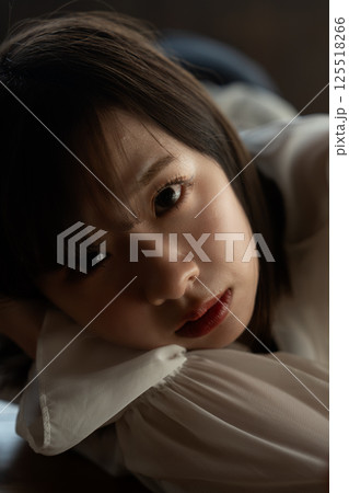 フローリングに寝転ぶクールな若い女性 フローリングに寝転ぶクールな若い女性 125518266